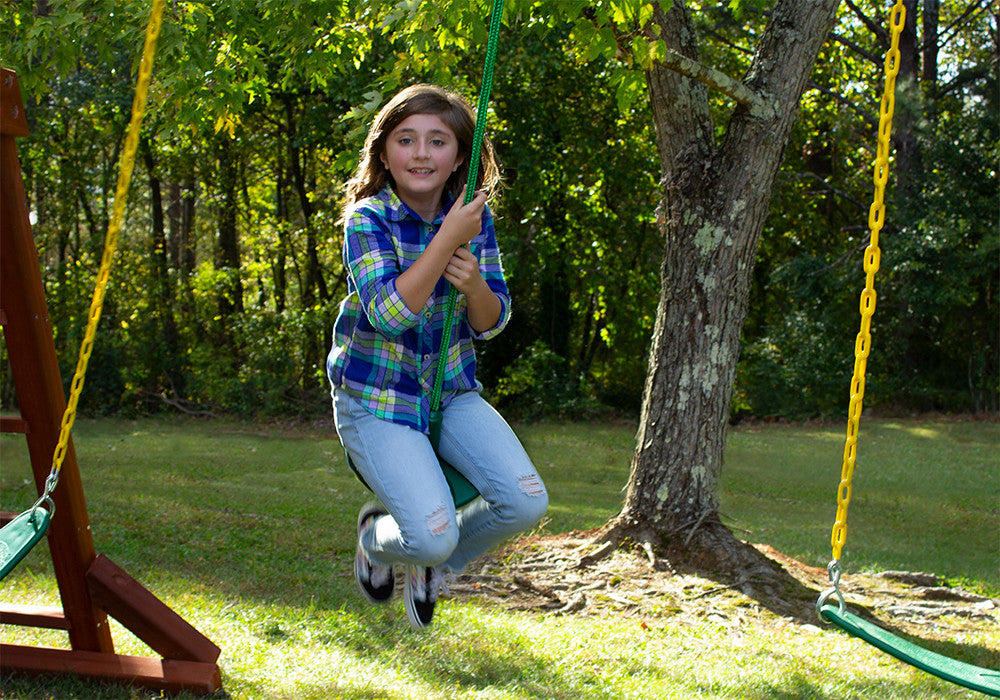 Outdoor shot of girl swinging on the Green Disc Swing from Gorilla Playsets Outdoor shot of girl swinging on the Green Disc Swing from Gorilla Playsets