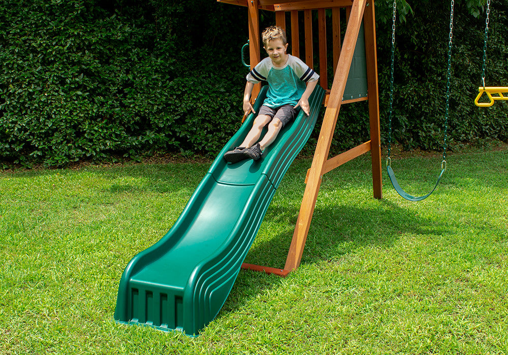 A boy sliding down the 2-Piece Cool Wave Slide from Gorilla Playsets
