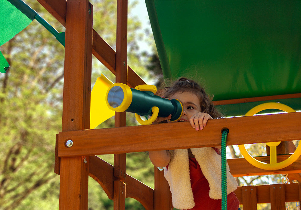 Girl looks through the green and yellow telescope with compass  from Gorilla Playsets.